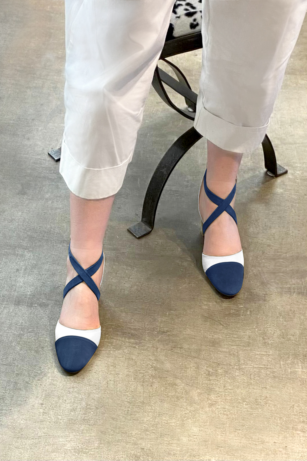 Navy blue and off white women's open side shoes, with crossed straps. Round toe. Medium comma heels. Worn view - Florence KOOIJMAN